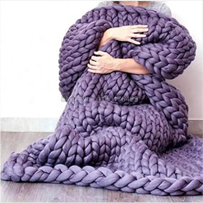 Chunky grey hand-knitted yarn roving throw blanket draped over a person.