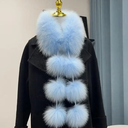 Light blue faux fox fur scarf with six large pom-poms, displayed on a black coat.