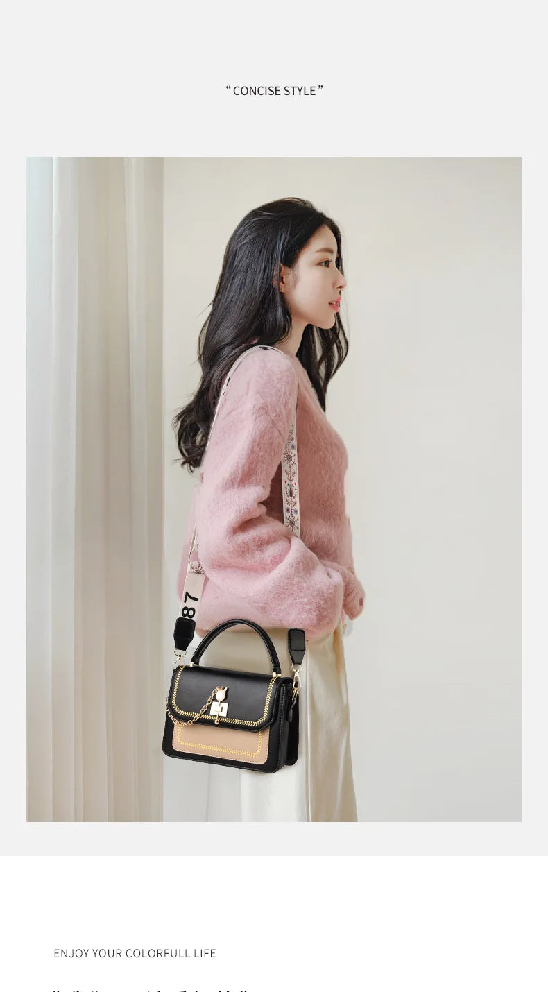 Black and beige leather structured handbag with gold hardware, top handle, and patterned webbing strap.