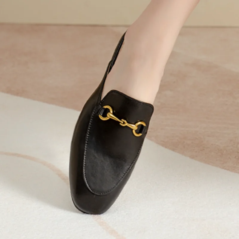 Black closed-toe slip-on shoes with gold-tone metal chain detail for outdoor wear.
