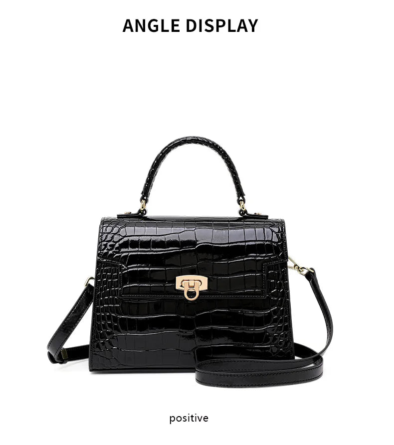 Black glossy crocodile-embossed leather handbag with a top handle, gold closure, and a crossbody strap.