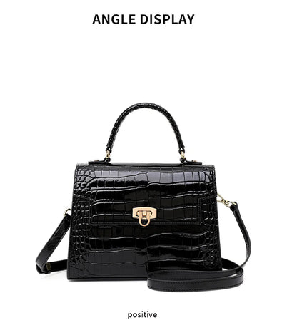 Black glossy crocodile-embossed leather handbag with a top handle, gold closure, and a crossbody strap.
