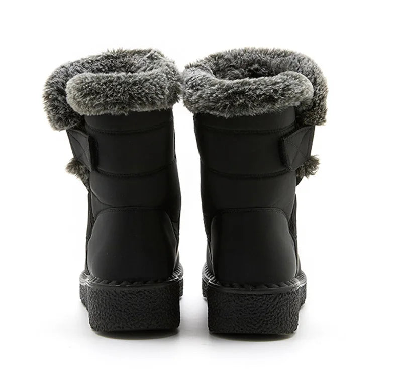 Black winter boots featuring gray faux fur trim, low heels, and hook-and-loop side straps.