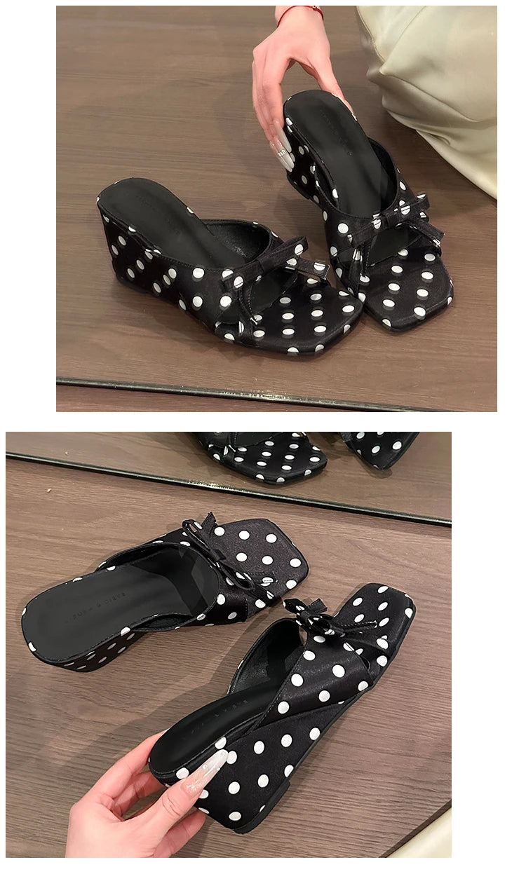 Black polka dot wedge sandals with a front bow detail and cushioned insole for casual wear.