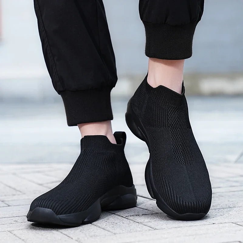 Black breathable knit slip-on sneakers with cushioned soles for daily casual wear.