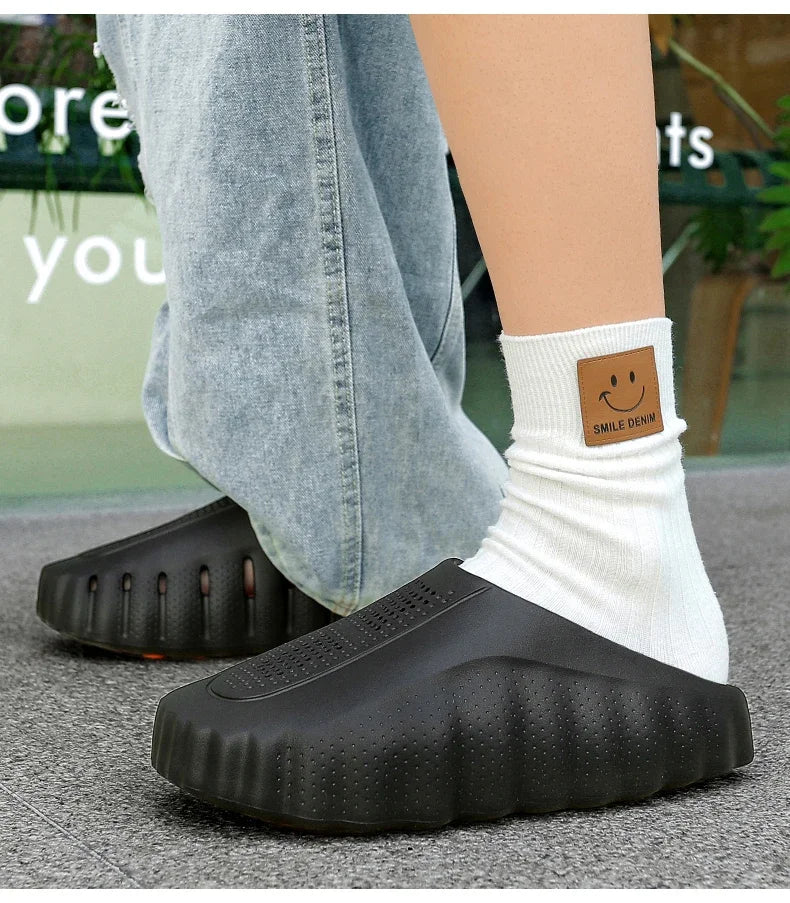 Black, slip-on platform sandals with a textured, thick sole for comfortable daily wear.