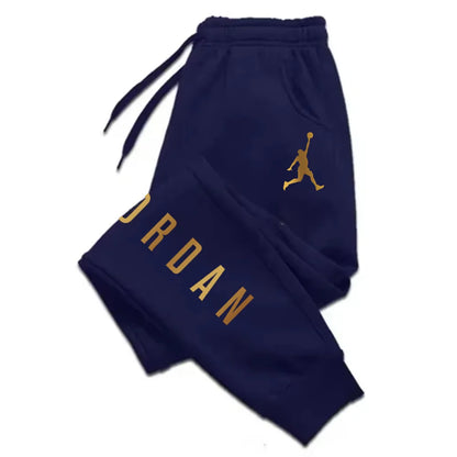 Navy blue midweight joggers with gold lettering, logo, and drawstring waist. Stretchy fitted pants for athletic wear.