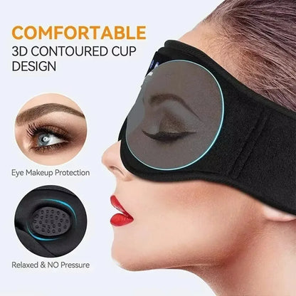 Black fleece wireless Bluetooth eye mask with 3D contoured cups and built-in speakers worn by a woman.