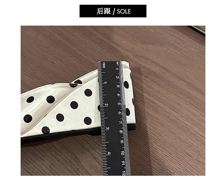 White and black polka dot wedge heel sandals with a cushioned insole for comfortable casual wear.