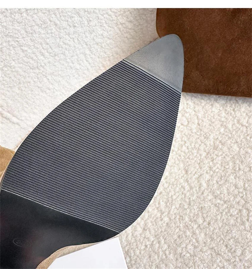 Brown suede high-heel boot sole with horizontal ribbing and a pointed toe.