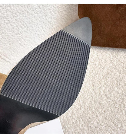 Brown suede high-heel boot sole with horizontal ribbing and a pointed toe.