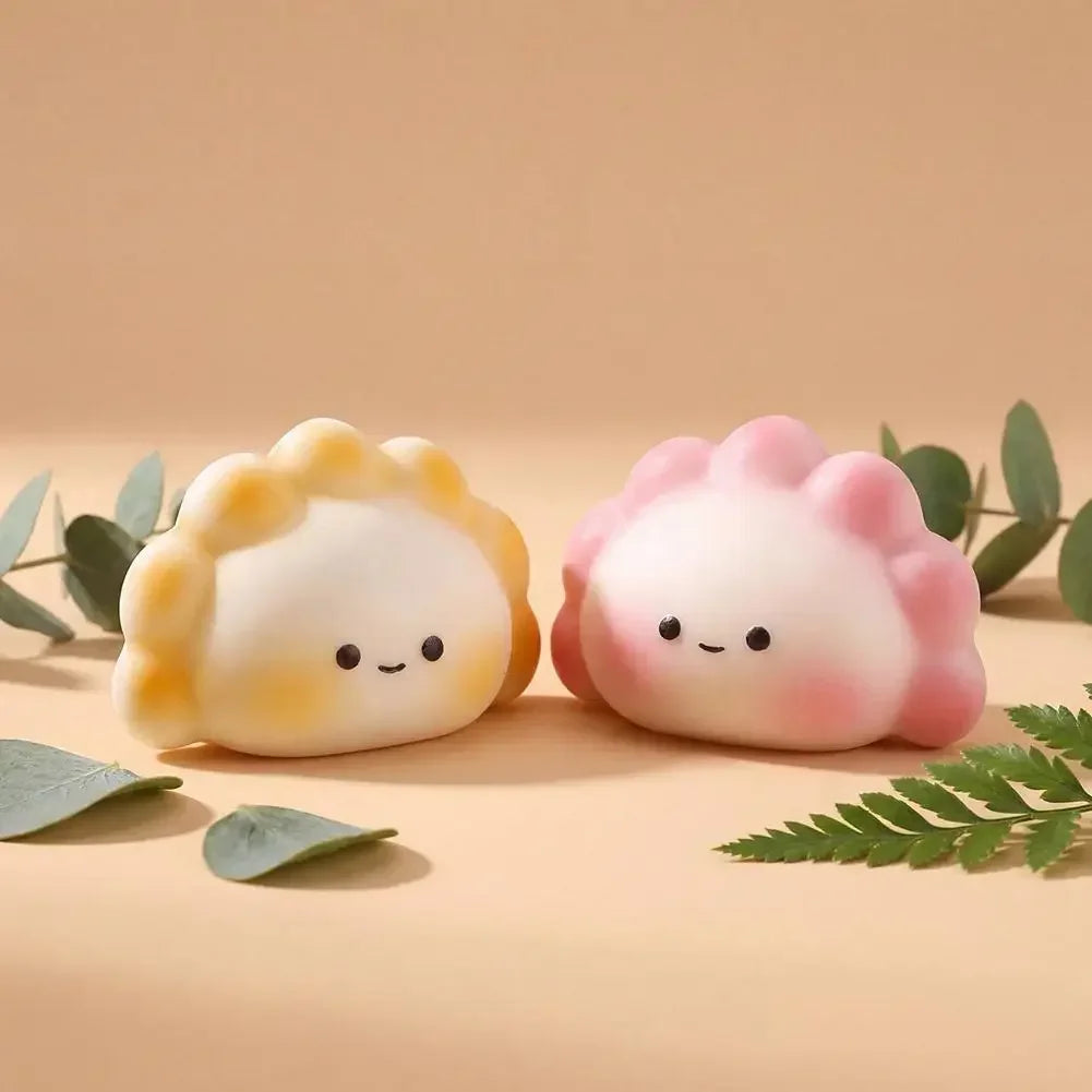 Two soft, yellow and pink dumpling-shaped squishy fidget toys for stress relief.