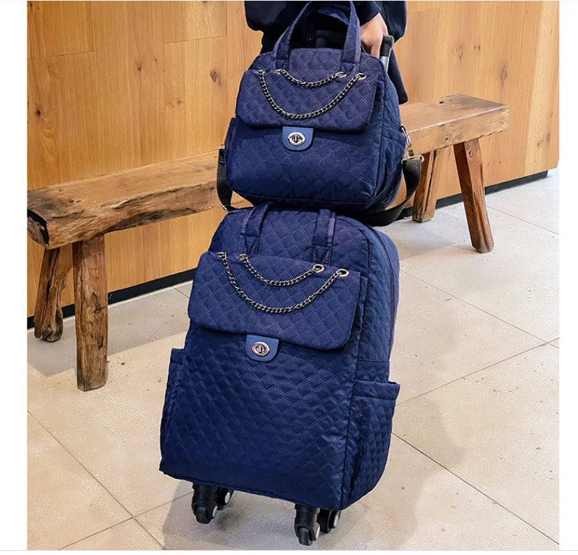 Navy blue quilted rolling backpack and matching handbag set with chain detail and twist-lock closures.