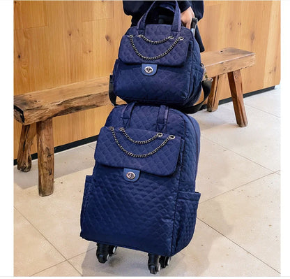 Navy blue quilted rolling backpack and matching handbag set with chain detail and twist-lock closures.