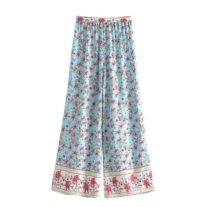 Light blue flowy wide leg drawstring pants with pink floral patterns, ideal for a bohemian outfit.