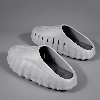 Light grey rubber slip-on sandals with a cushioned thick sole and perforated texture for comfortable daily wear.