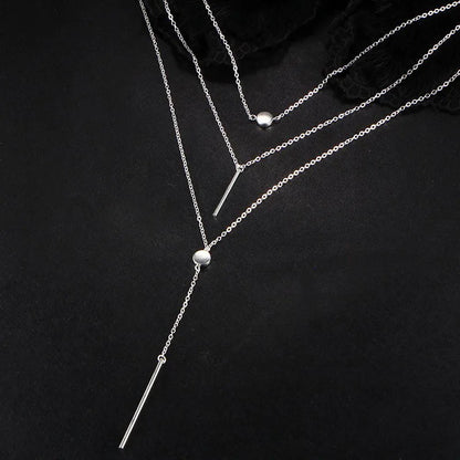 Women's gold-tone layered chain necklace with pendant detail