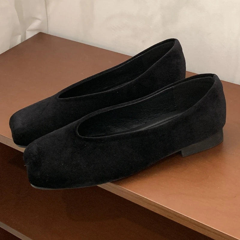 Black suede slip-on flats with a squared toe for comfortable daily wear.