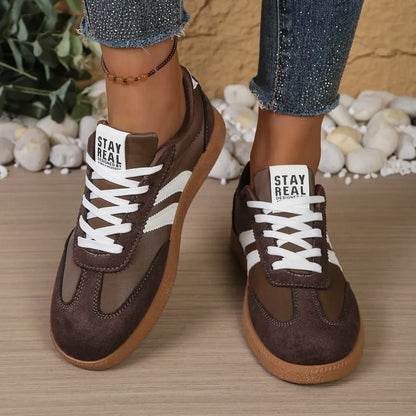 Brown leather slip-on sneakers with white stripes, white laces, and gum soles for casual daily wear.