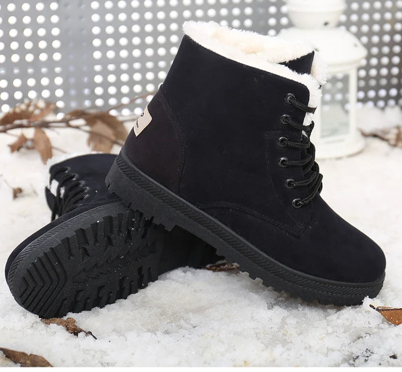 Black suede ankle snow boots with white faux fur lining, black laces, and ridged rubber soles.