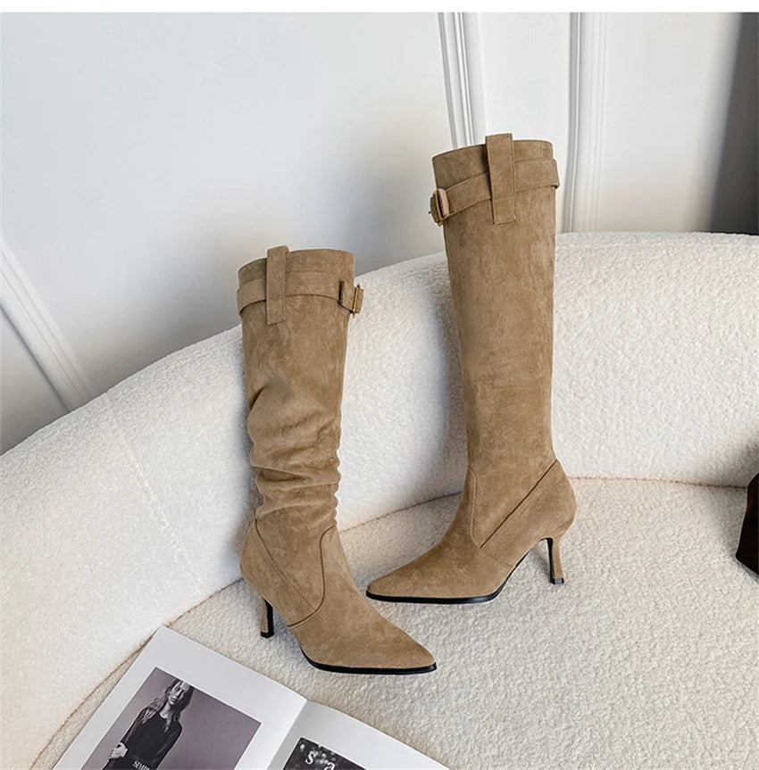 Khaki suede pointed-toe high heel boots with a buckle strap and slouchy shaft.