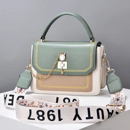 Sage green, tan, and white faux leather structured handbag with gold embroidery, chain detail, and a patterned strap.