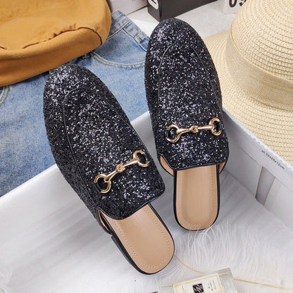 Black glitter slip-on shoes with gold chain detail, suitable for all day wear.