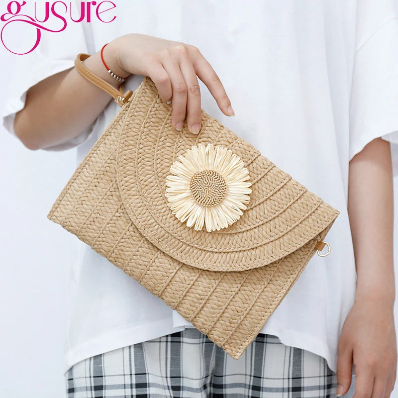 Beige straw woven envelope crossbody bag with a floral detail for beach days.