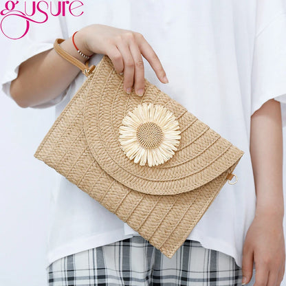 Beige straw woven envelope crossbody bag with a floral detail for beach days.