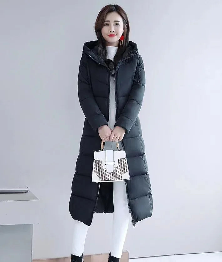 A woman wearing a black long hooded puffer parka jacket with horizontal quilting.