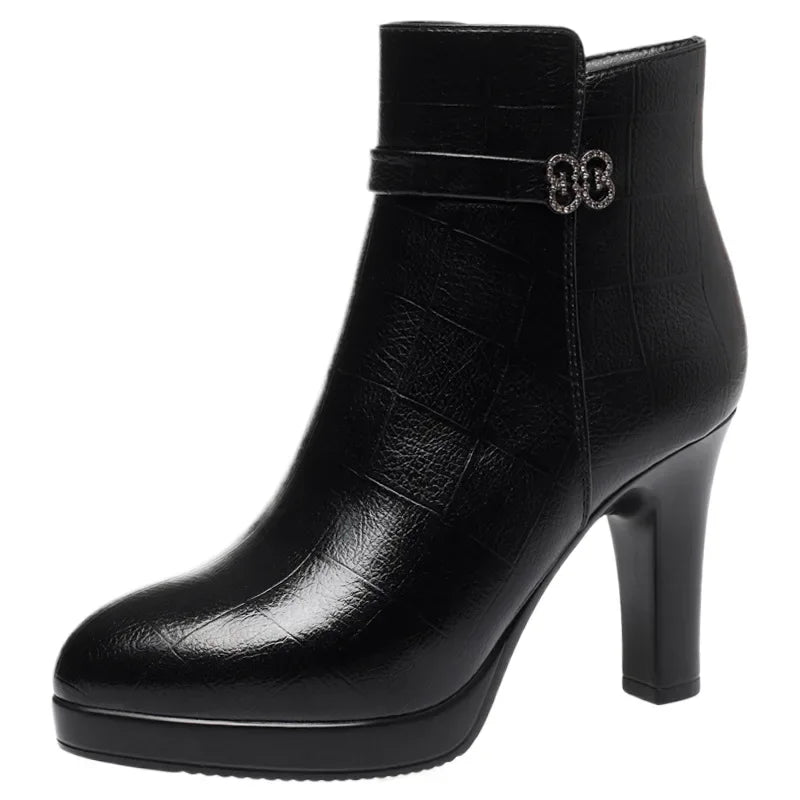 Black ankle boot in textured leather with a platform, high block heel, and rhinestone buckle strap.