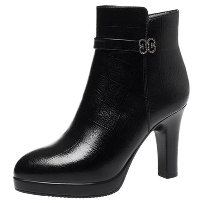 Black ankle boot in textured leather with a platform, high block heel, and rhinestone buckle strap.