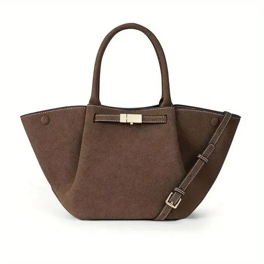 Women's suede tote bag with top handles and metal bar closure shown from the side
