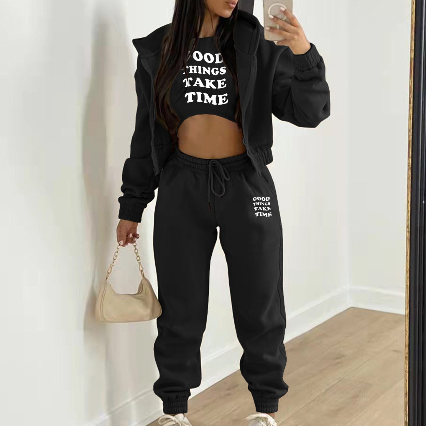 Black plush knit sweater set with a white letter print, featuring a relaxed hooded zip-up and high waist joggers.