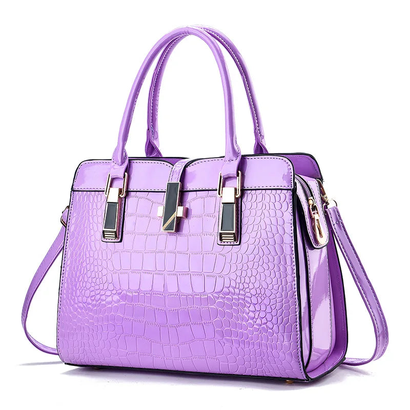 Purple faux leather tote bag with crocodile pattern, top handles, shoulder strap, and gold-tone hardware.