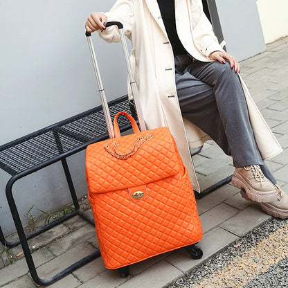 Bright orange quilted PU rolling suitcase with a top handle, turn-lock closure, chain detail, and telescoping handle.