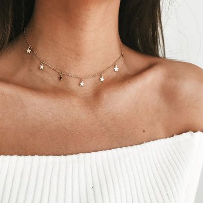 Gold star choker necklace on a person's neck.