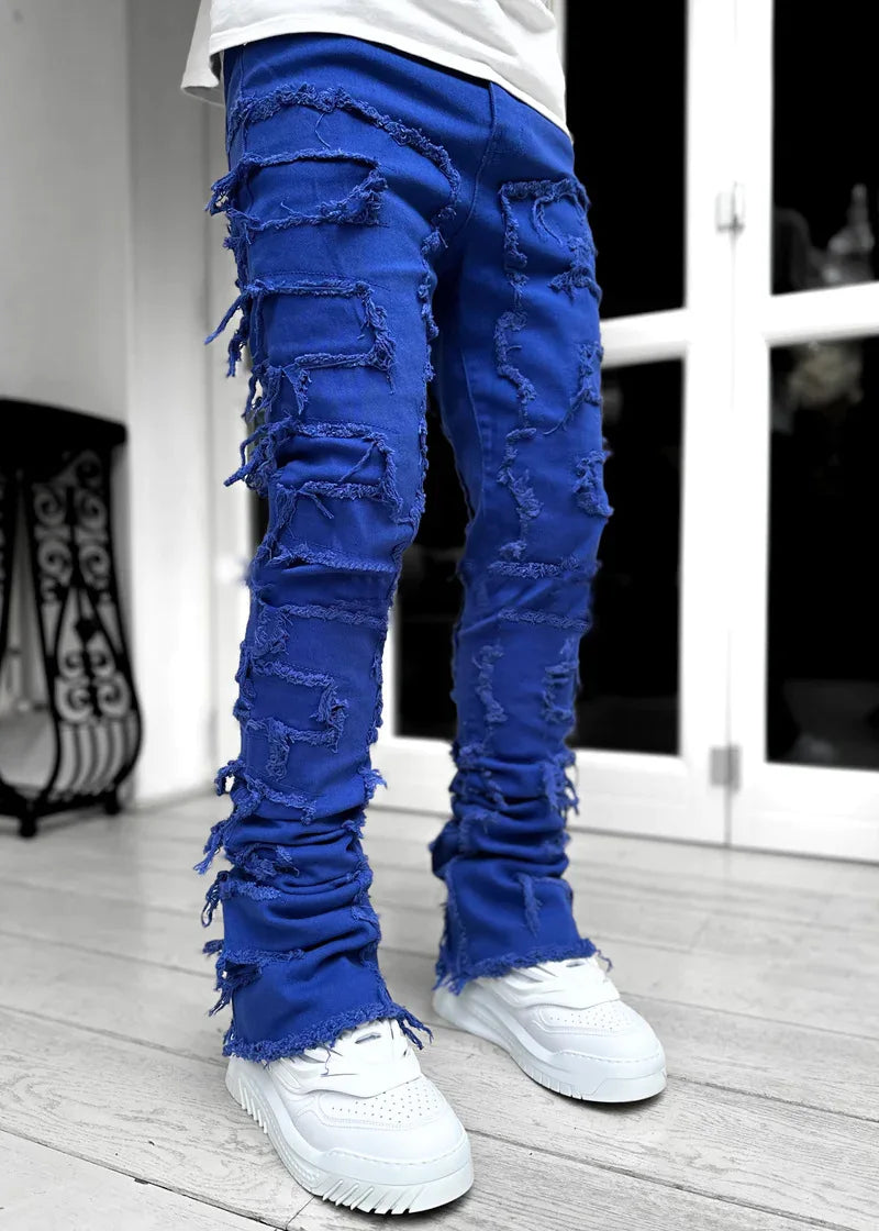Bright blue distressed patchwork jeans with frayed tassel details and a fitted silhouette for a street-style look.