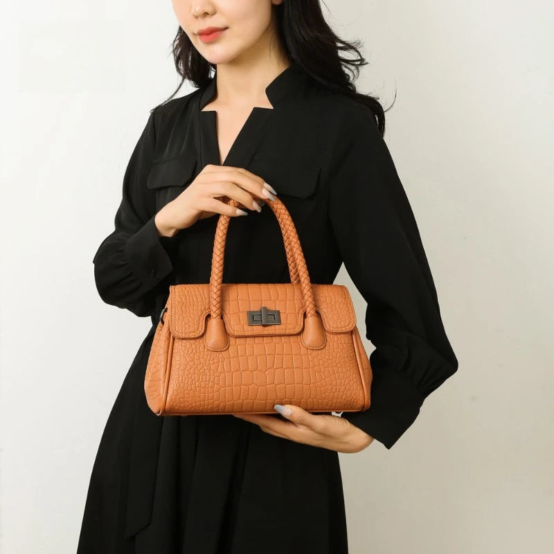 Tan faux leather structured messenger bag with braided handles and croc pattern for everyday use.
