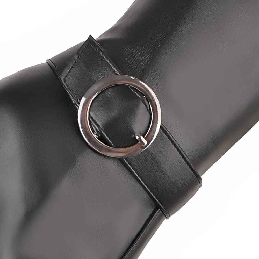 Black faux leather tall boot detail, featuring a strap secured by a round metallic buckle.