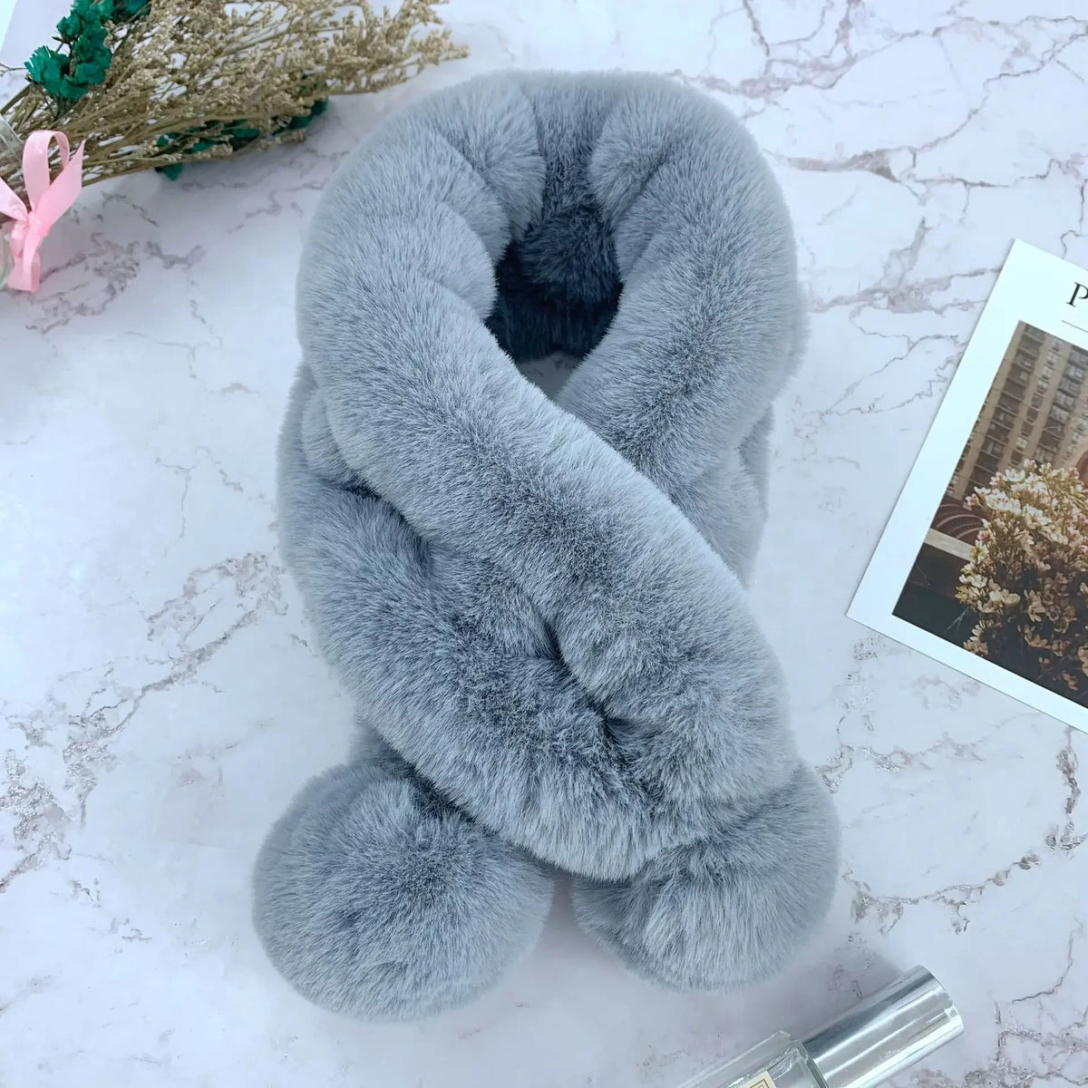 Grey plush faux fur cross-over scarf with fluffy pom-pom ends.