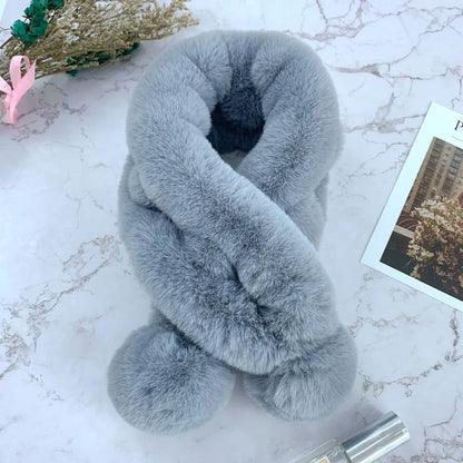 Grey plush faux fur cross-over scarf with fluffy pom-pom ends.