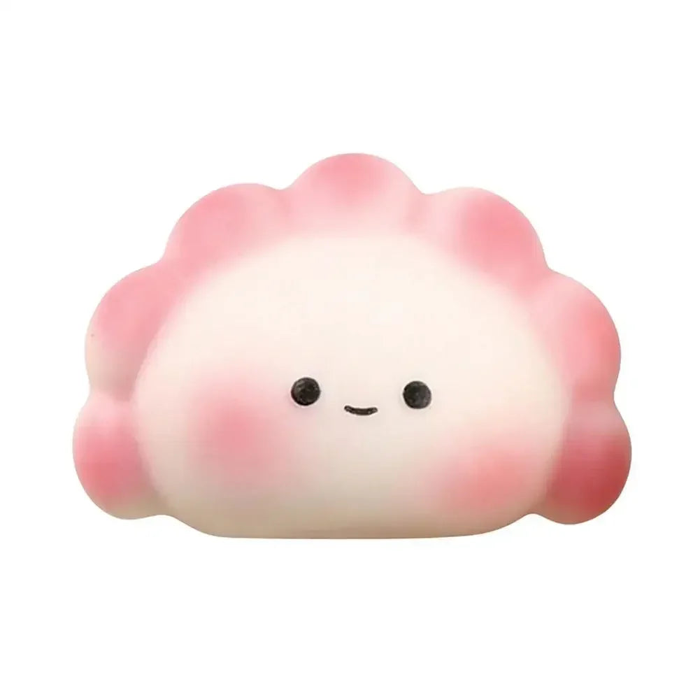 White and pink rubber dumpling squishy fidget toy with a smiling face for portable stress relief.