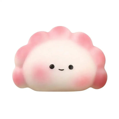 White and pink rubber dumpling squishy fidget toy with a smiling face for portable stress relief.