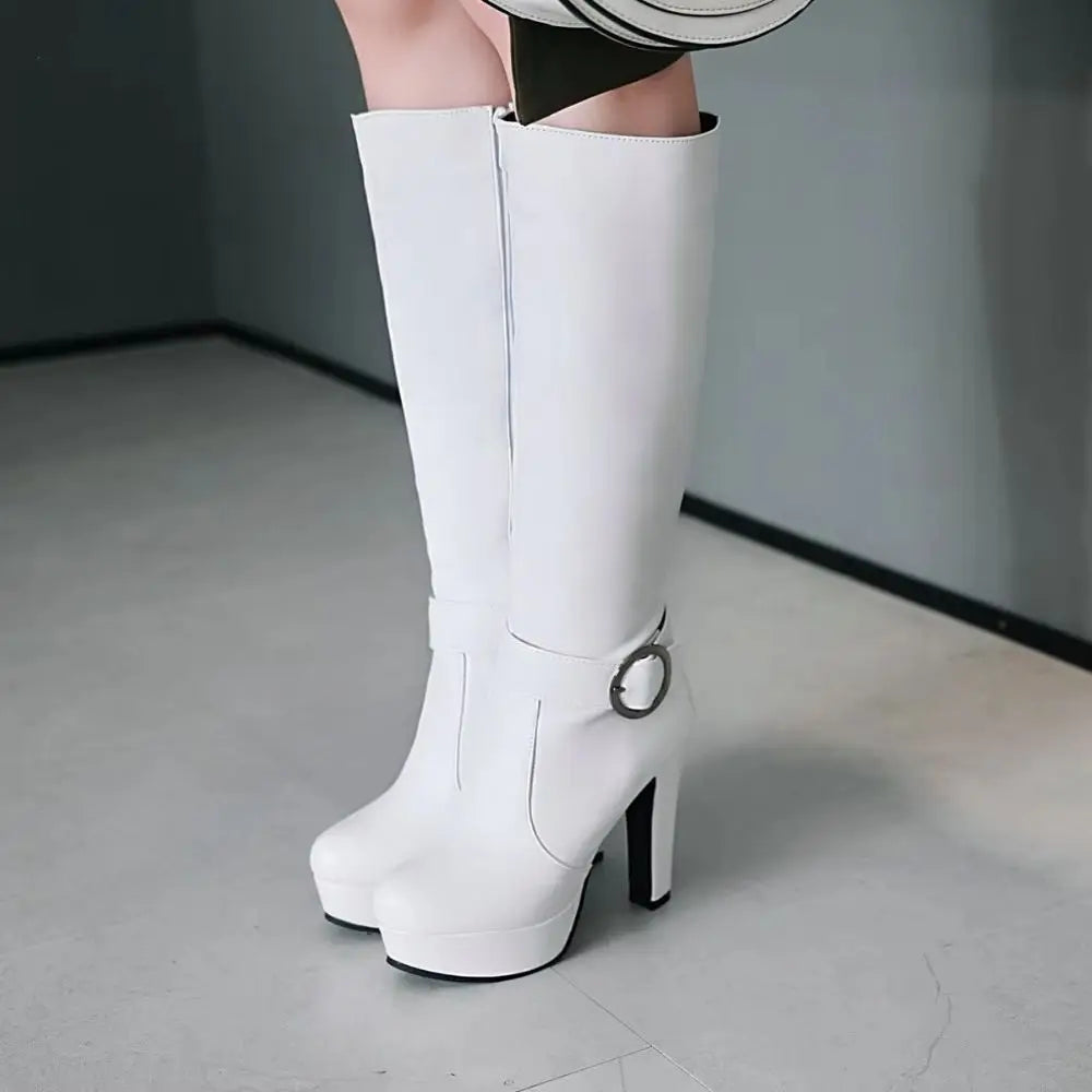 White knee-high platform boots in faux leather with a high heel, round toe, and ankle buckle strap.