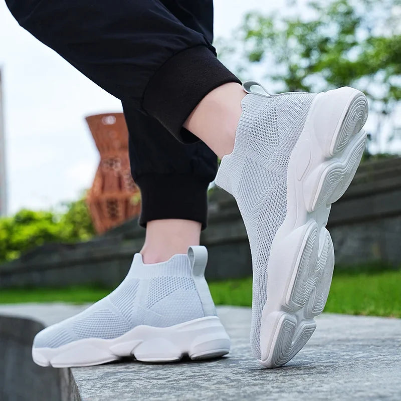 Light grey knit moccasin sneaker with breathable mesh and cushioned white soles for walking.
