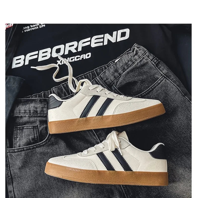 White canvas sneakers with black stripes and gum soles. Breathable casual training shoes for daily athletic activity.