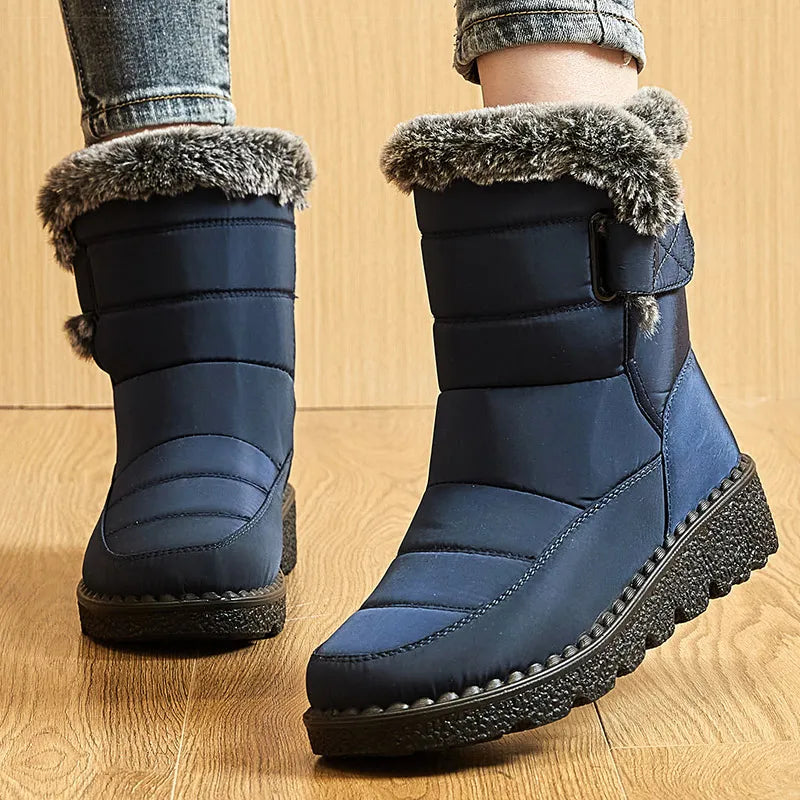 Navy blue waterproof winter boots with quilted shafts, faux fur trim, side strap, and black platform soles.