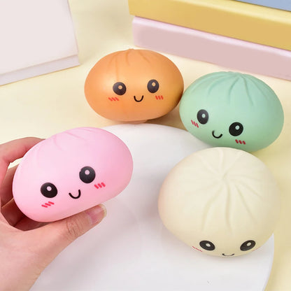 Hand holding colorful silicone dumpling squishies fidget toy with mystery collectible facial designs for stress relief.