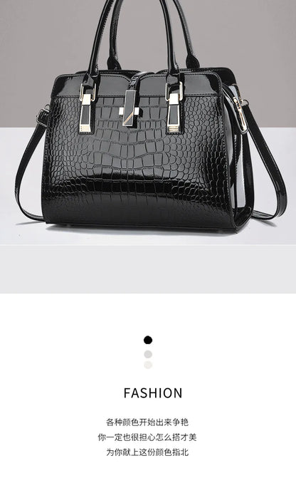 Black patent leather crocodile-pattern tote bag with dual top handles and gold-tone hardware.